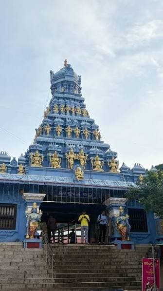 Blue temple gopuram with golden deity sculptures at Kadri, Mangaluru
